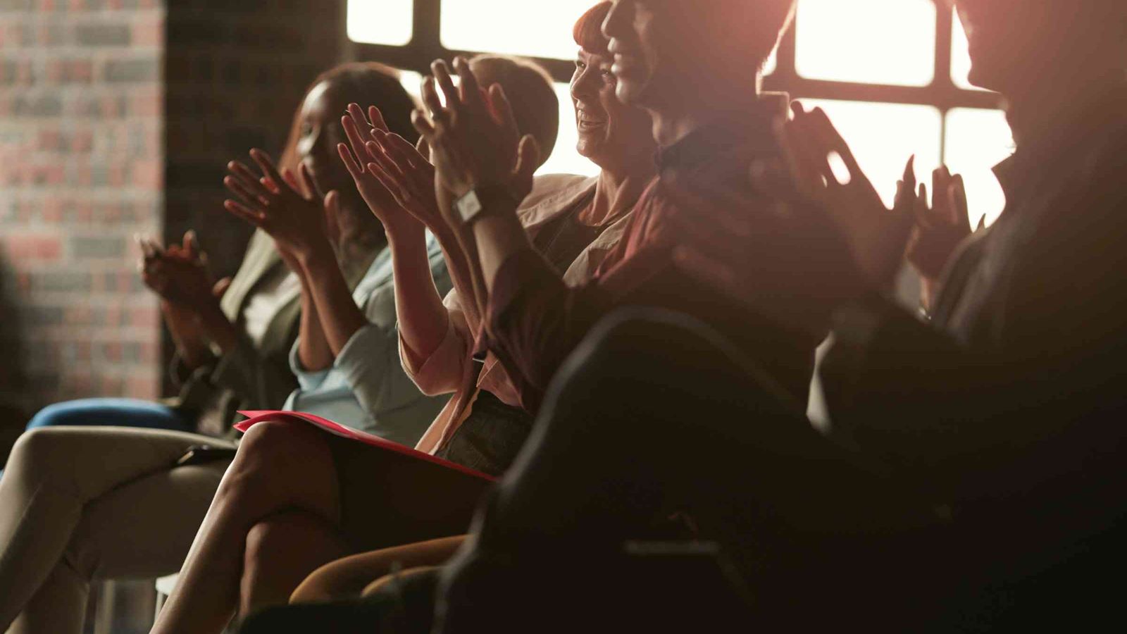 Delegates clapping at a presentation