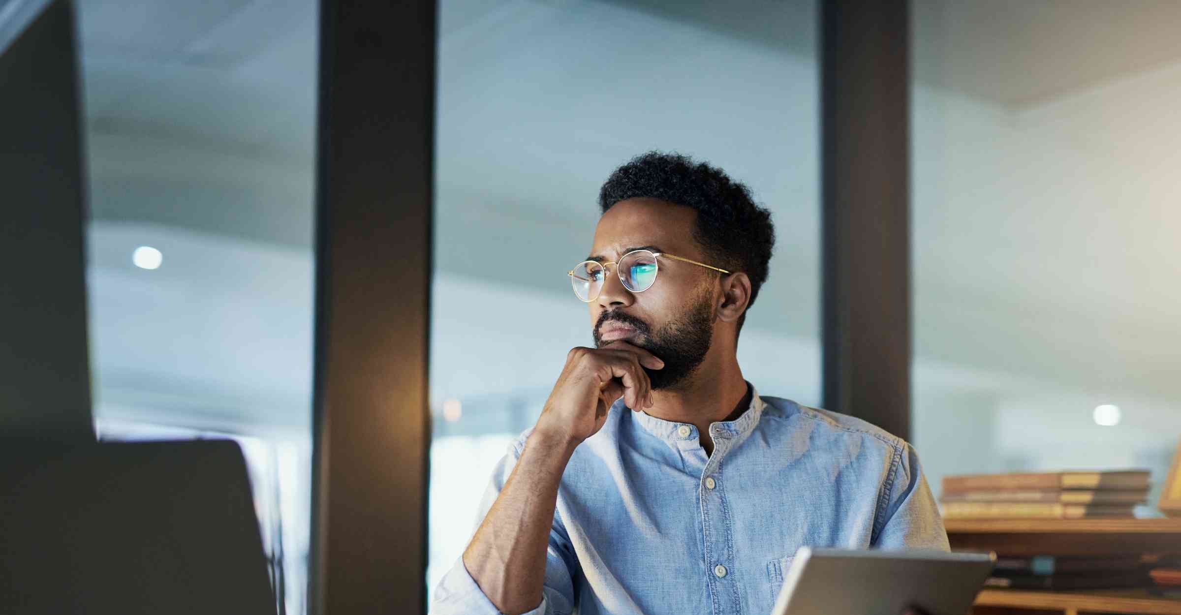 Professional man staring a screen while holding a tablet