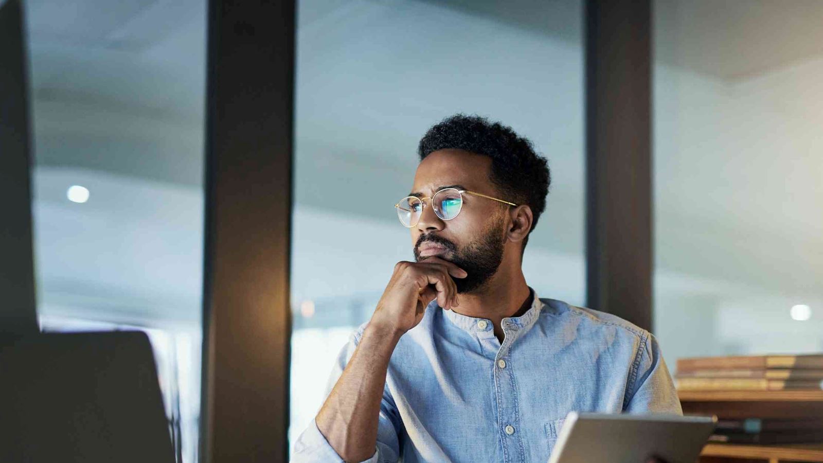 Professional man staring a screen while holding a tablet