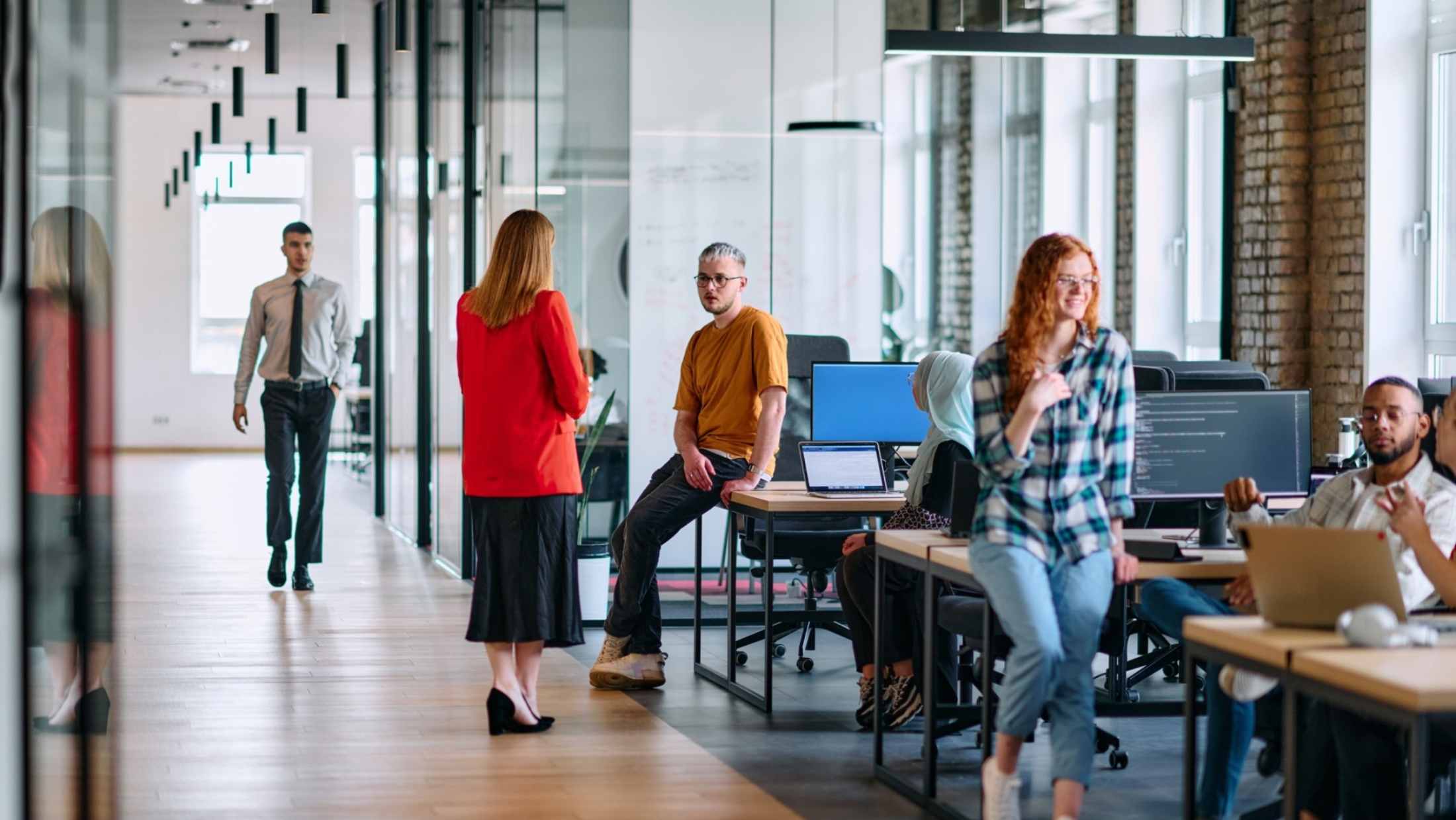 A diverse group of young business individuals congregates in a modern startup coworking center