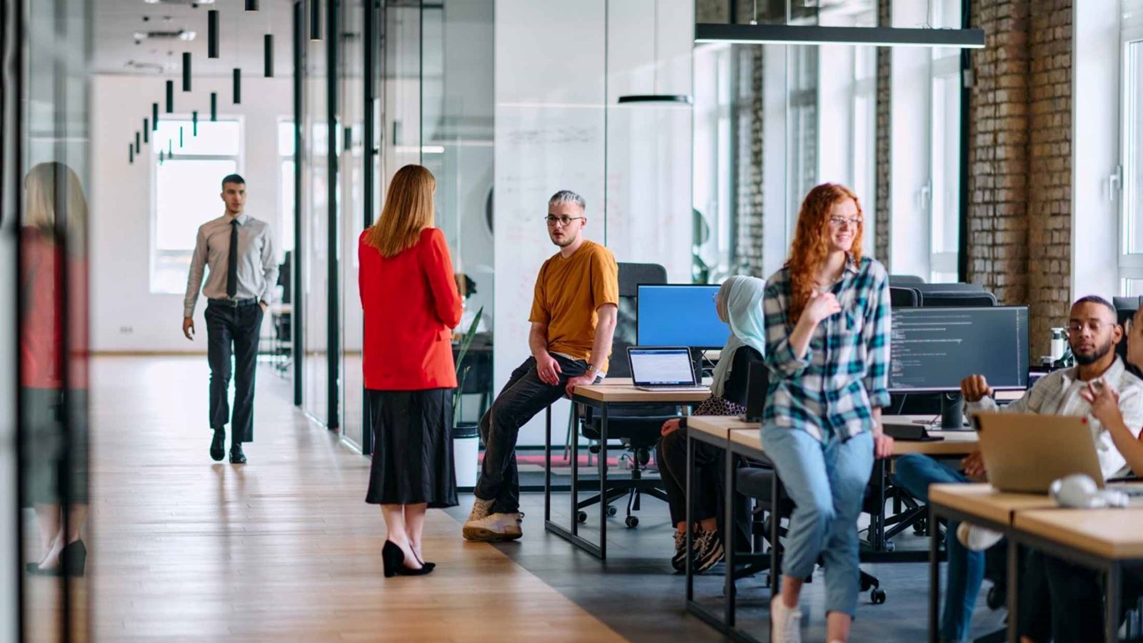 A diverse group of young business individuals congregates in a modern startup coworking center