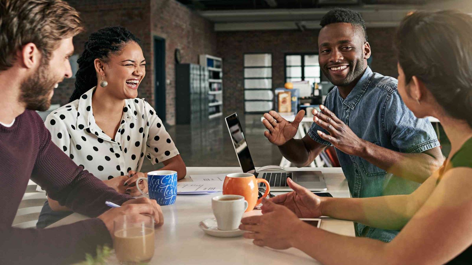 Group of four co workers sitting round a desk