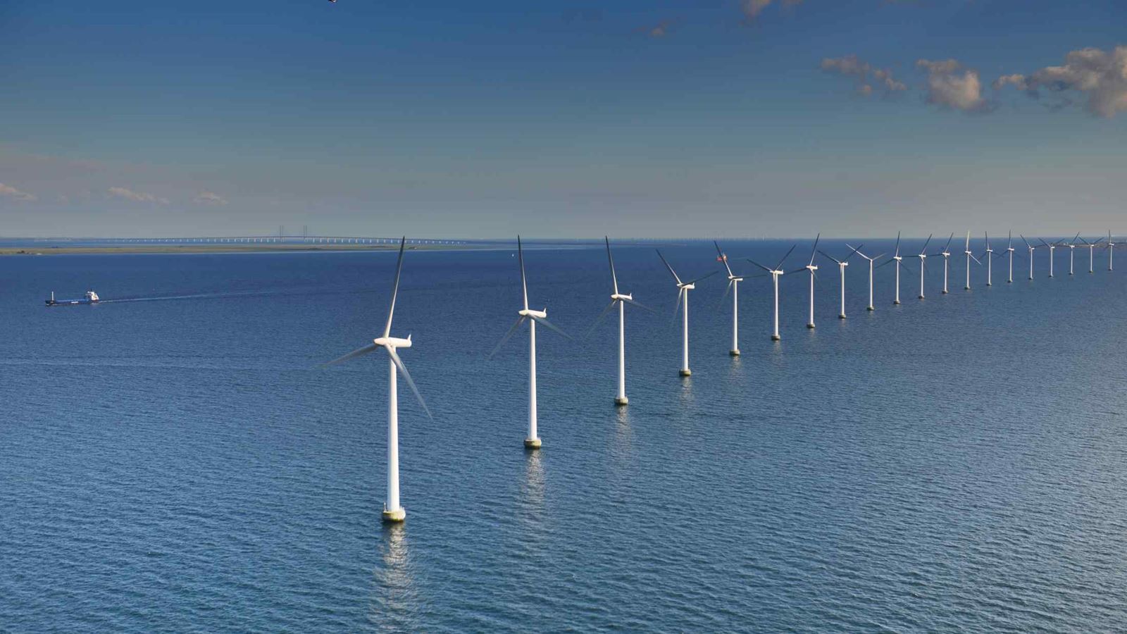 line of white wind turbines in the sea