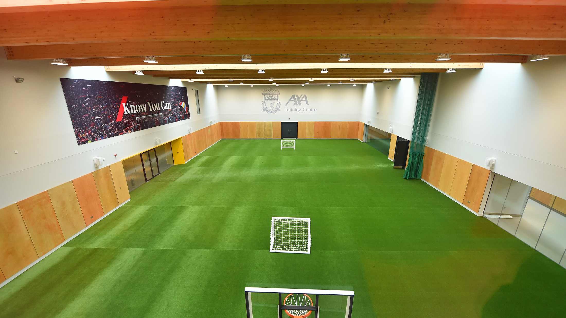 Indoor football training pitch with the AXA logo and the know you can logo on the wall