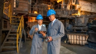 Male and female engineers using a digital tablet while standing in the foundry.