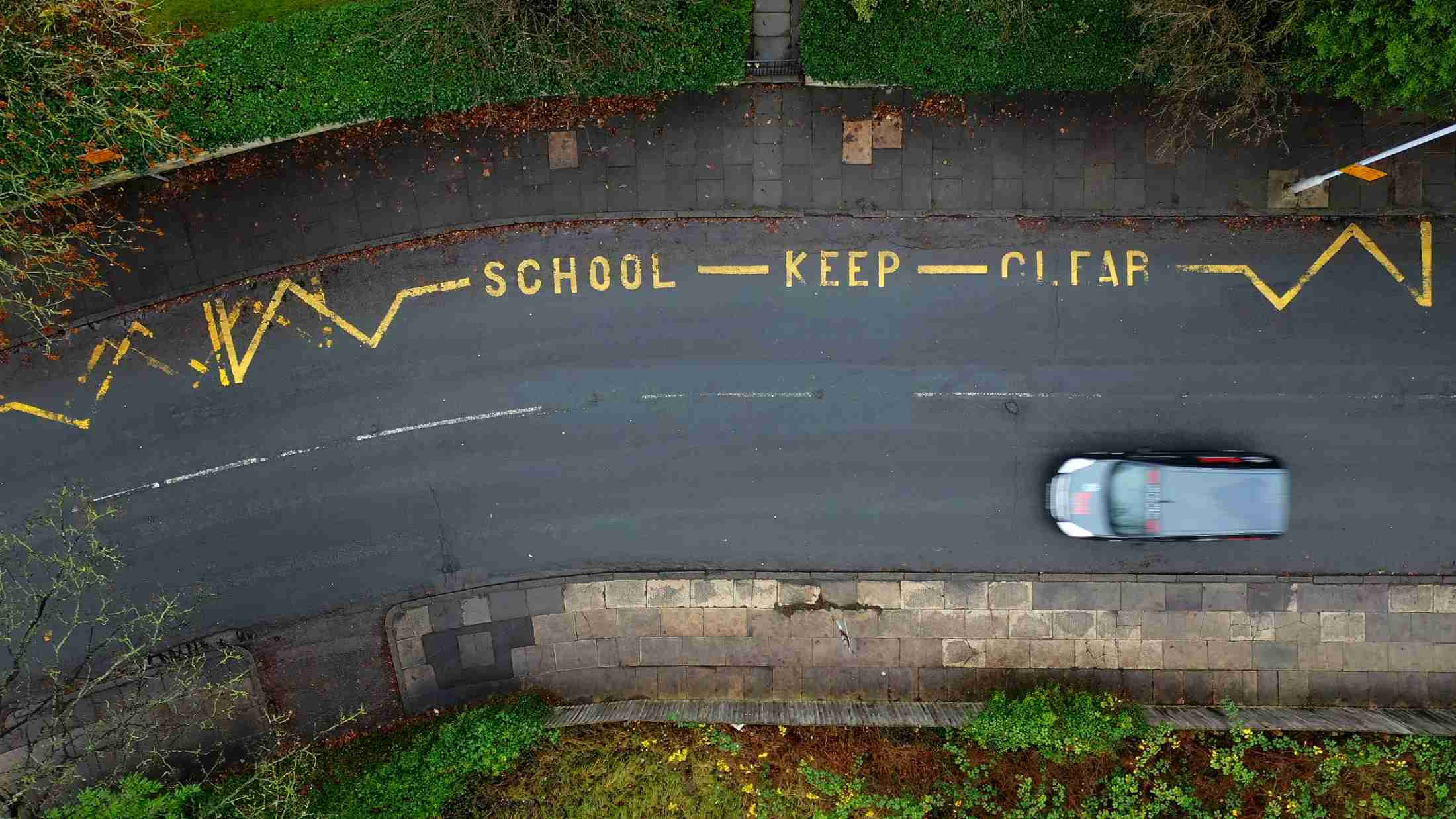 Aerial view of a taxi driving down a road