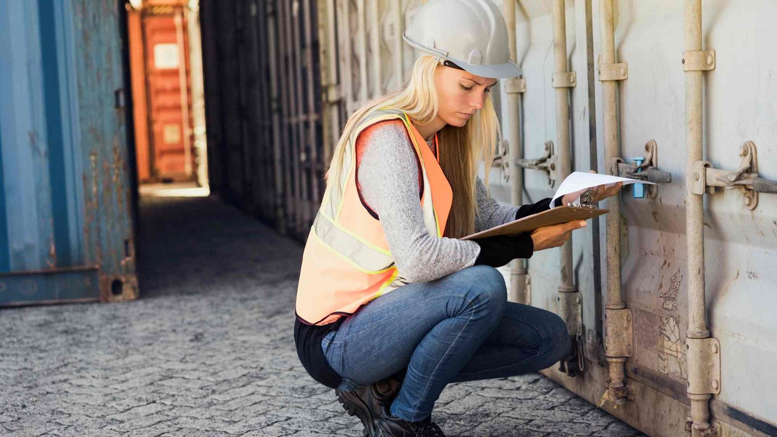 Person wearing a hard hat holding a clipboard