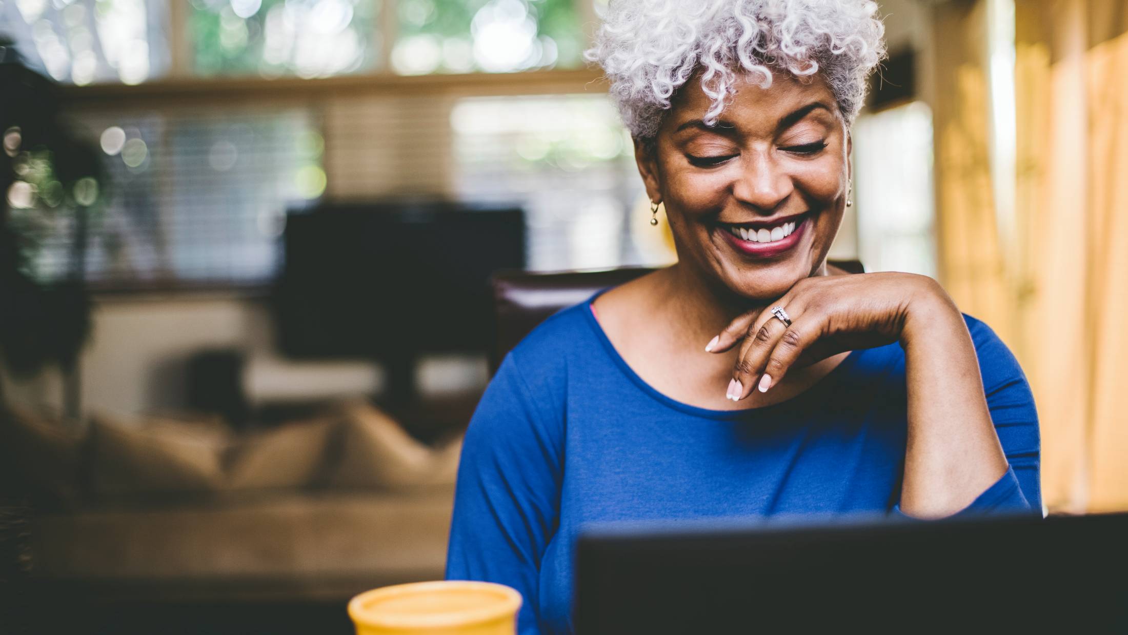 Woman smiling while working on her laptop