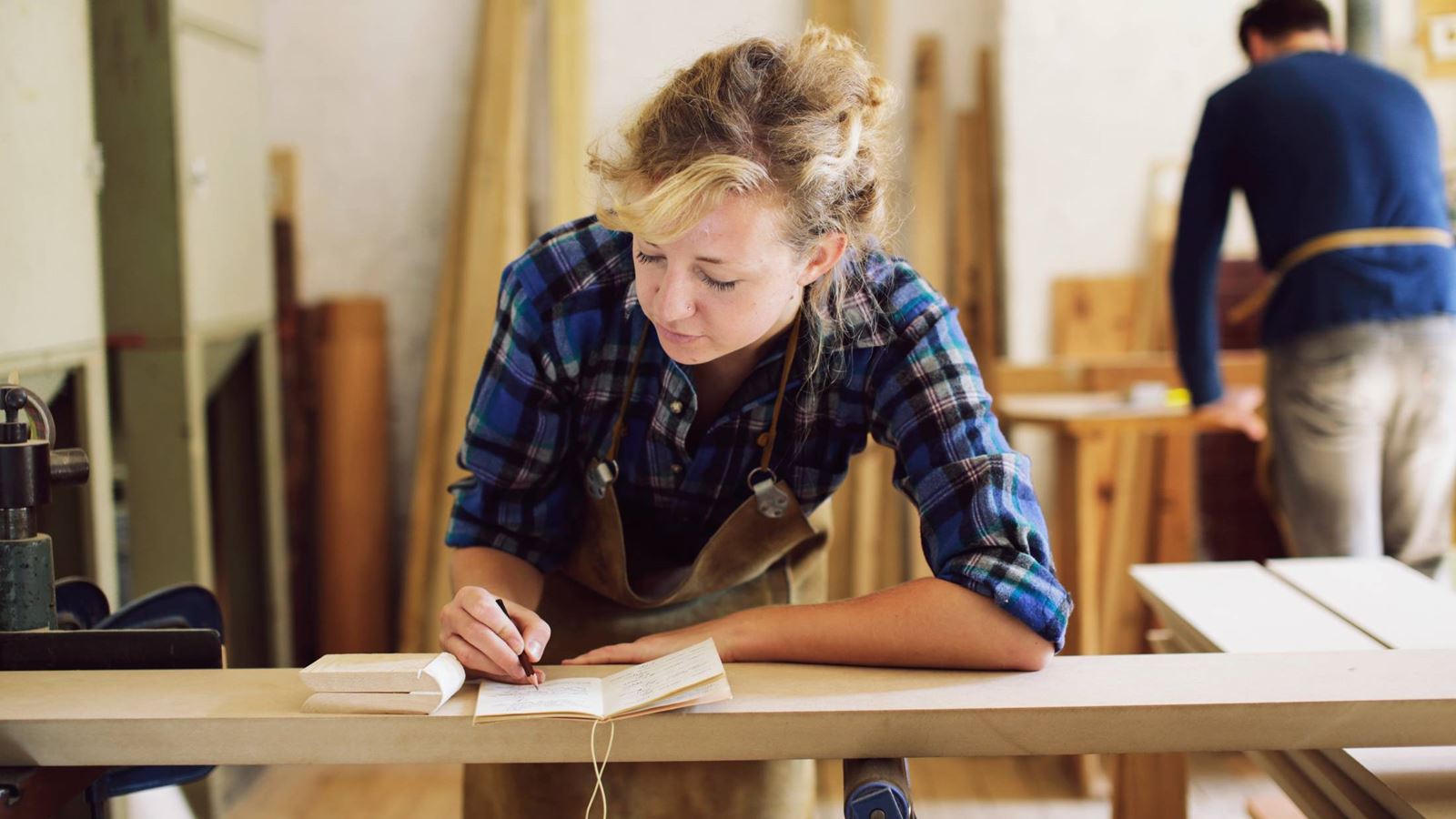 Woodworker making notes in a workshop