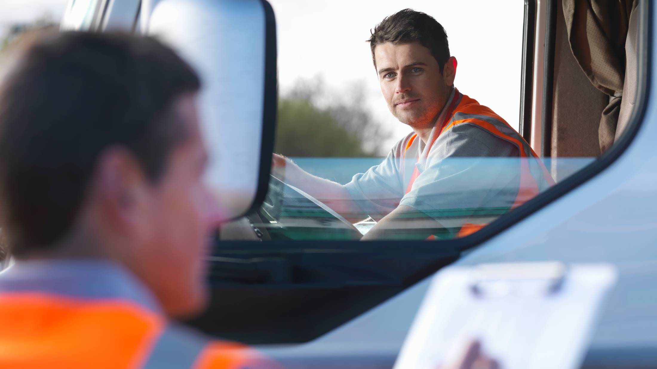 Driver in a truck wearing a high visibility jacket