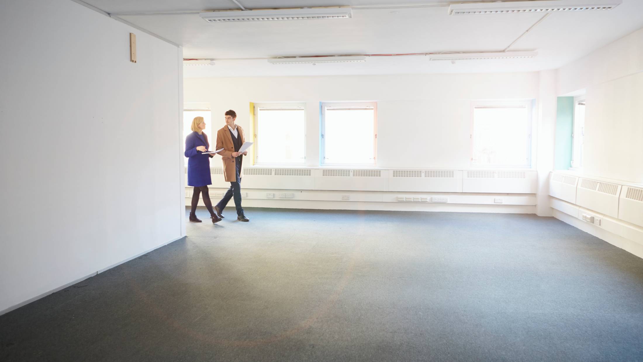 Two people walking around an empty building