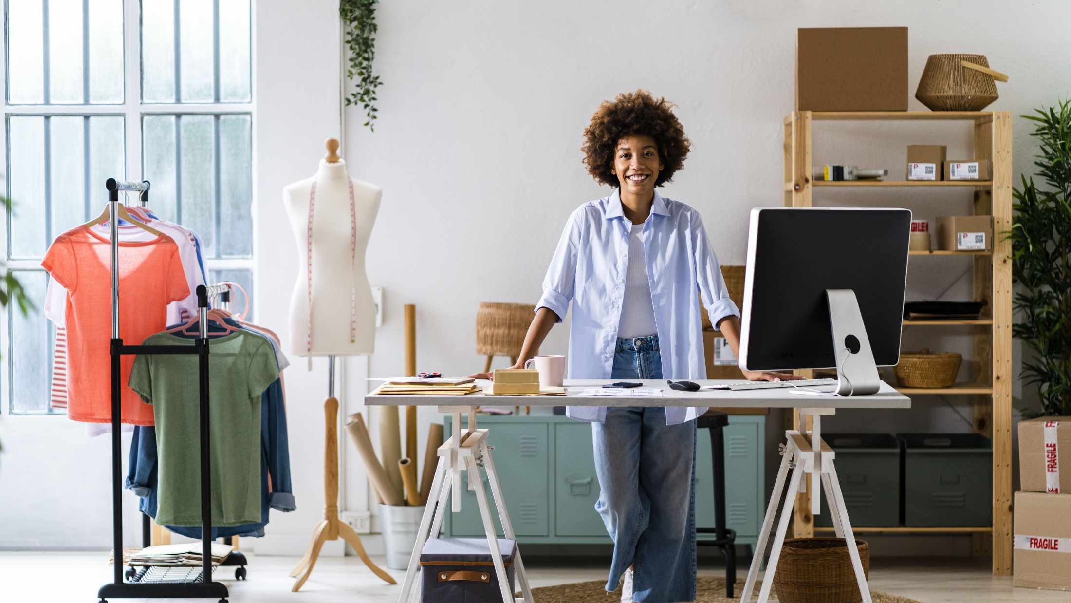 Young black woman stood behind a counter in a small independent shop