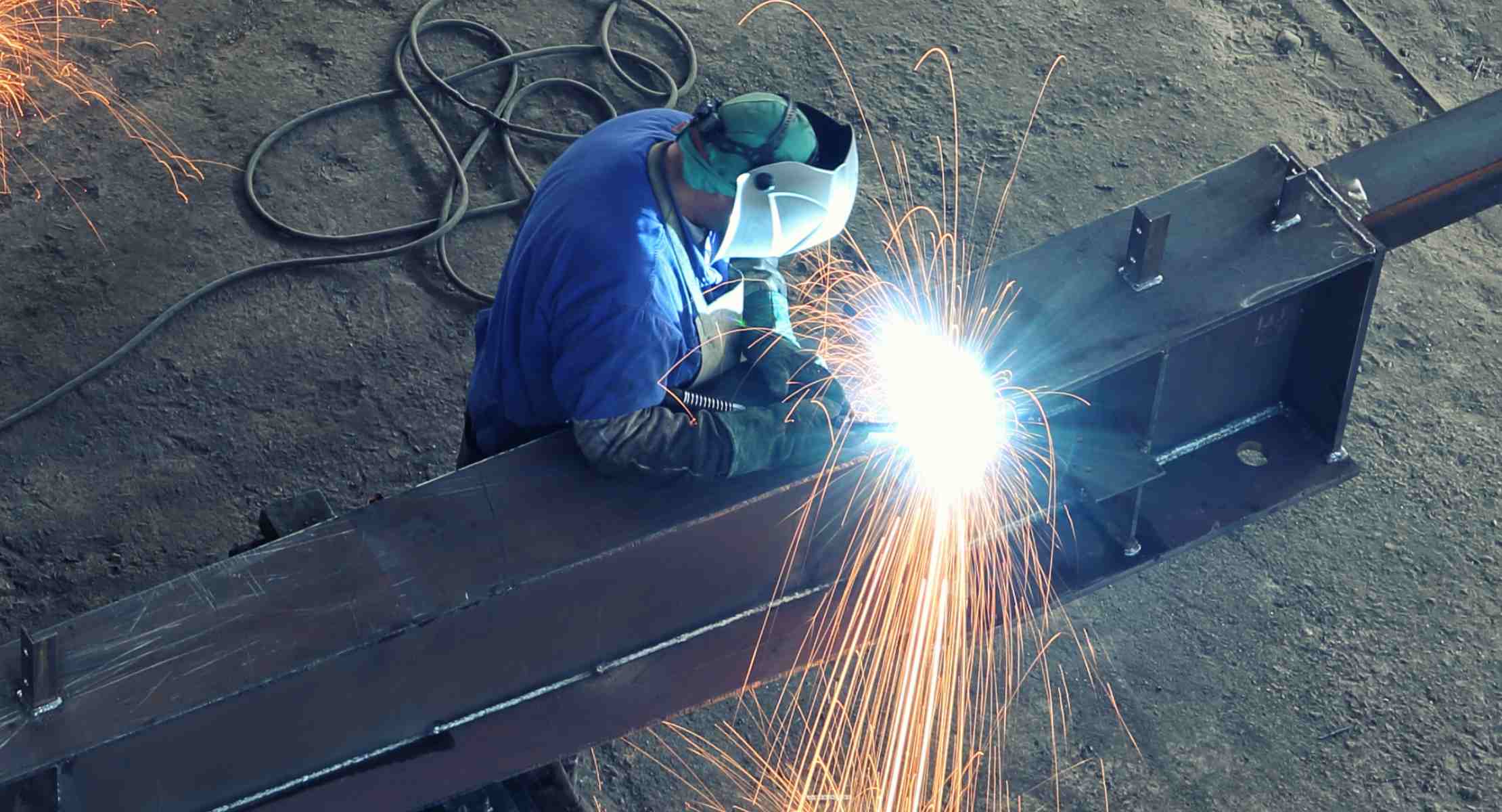 Person welding steel in protective outfit