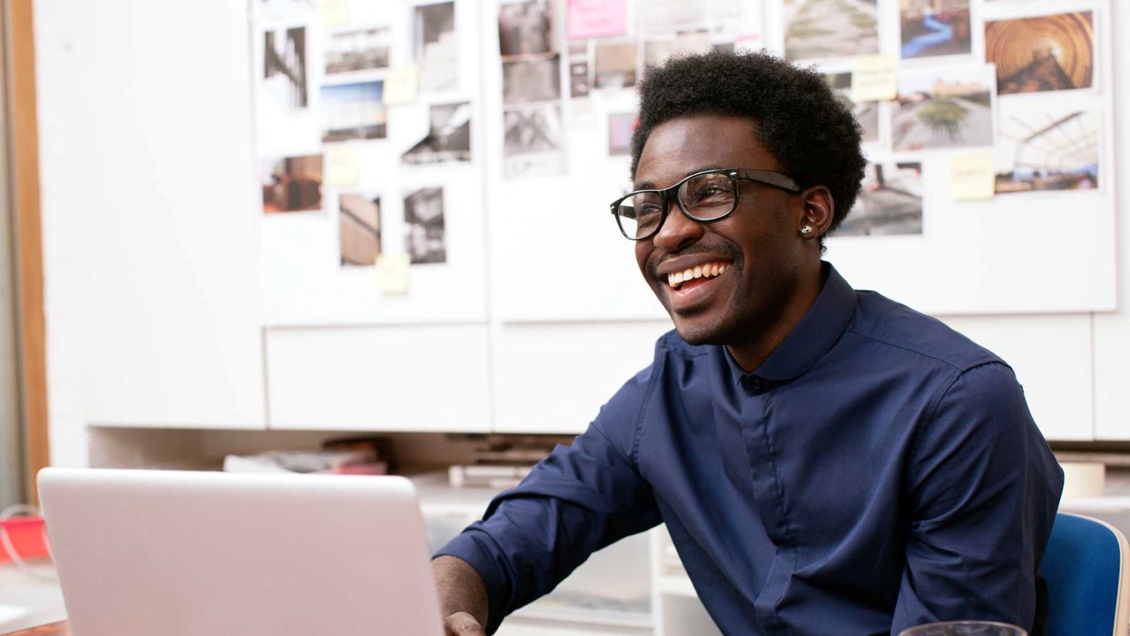 A young man working at his desk in a creative office environment