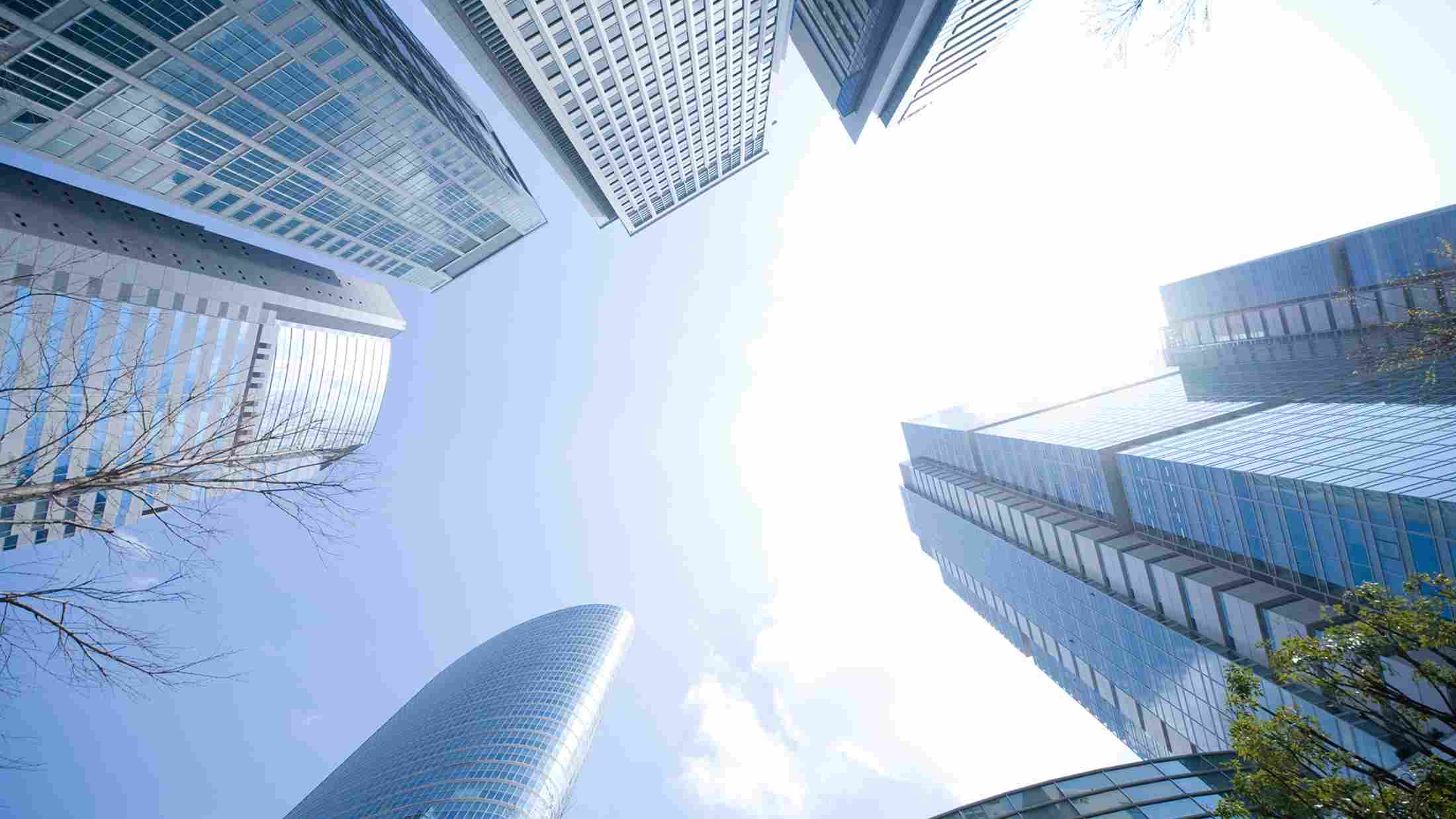 Image of skyscraper glass buildings taken from the ground pointing at the sky