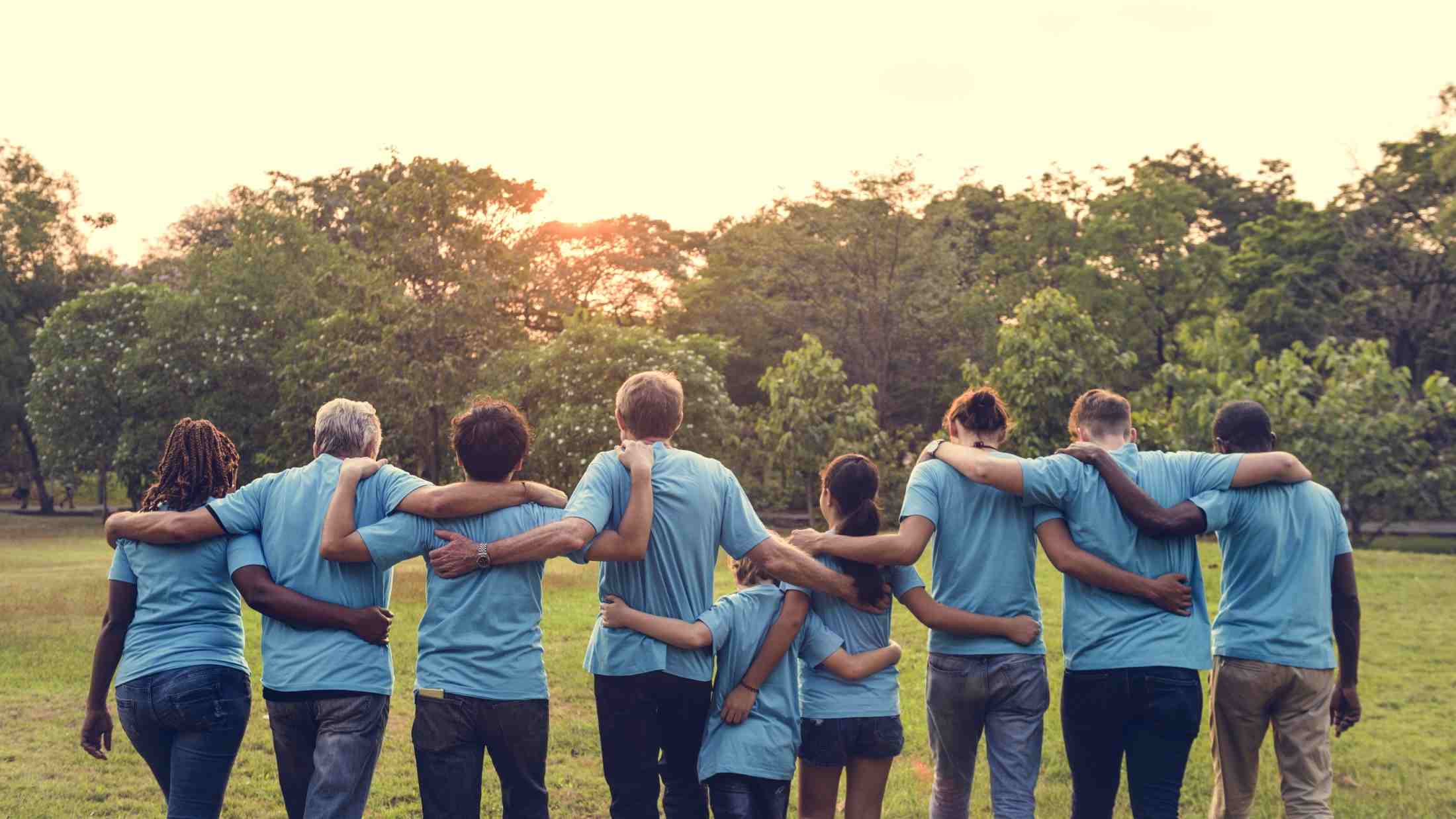 Group of volunteers stood in a line with their arms interlaced