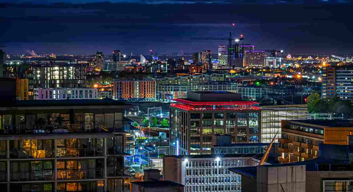 Manchester city scape by night - lots of tall blocks of offices lit up