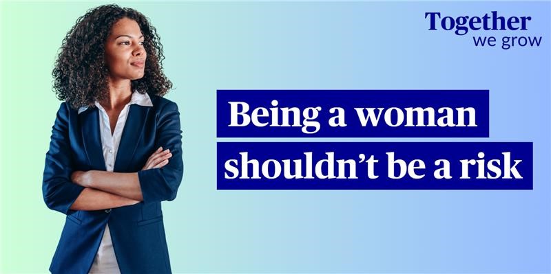 Blue background with a woman in a business suit folding her arms on the left and the text 'Being a Women Shouldn't be a Risk' on the right